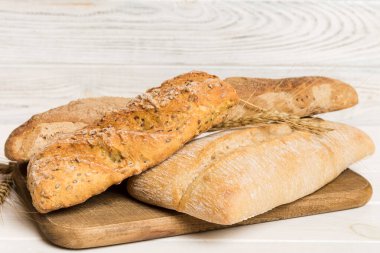 Tahtanın üzerinde beyaz ahşap zemine karşı taze pişmiş ekmek. Ekmeği kopyalama alanı ile perspektif görünümü.