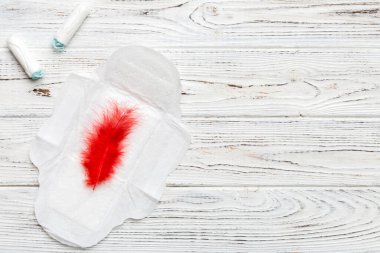 Kadın pedleri ve tamponları. Pembe ve menekşe arka planda izole edilmiş bir arka planda hijyenik pedlerin yanında uzanıyor. Kadın hijyeni ve adet dönemi konsepti.