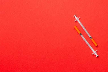 Renkli arka planda fotokopi alanı olan iki insülin şırıngasının üst görüntüsü. Yüksek seviyedeki glikoz konsepti.