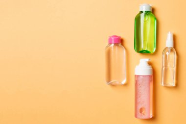 Kozmetik SPA marka modeli, fotokopi alanı olan üst görünüm. Renkli arka planda duran krema tüpleri ve kavanozları..