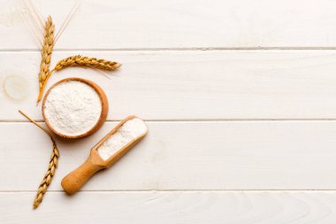 Tahta kasede buğday unu ve renkli arka planda buğday dikenleri. dünya buğday krizi.