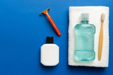 Masada banyo kozmetik ürünleri olan bir kompozisyon. jilet, diş macunu, sabun, jel, diş fırçası, gargara ve diğer çeşitli aksesuarlar. Cilt sağlığı için kozmetik. Logonuz için Bath Mockup.