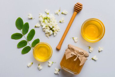 Akasya çiçekli ve yapraklı bal kavanozu. Taze bal üst görünüm düz yatıyordu.