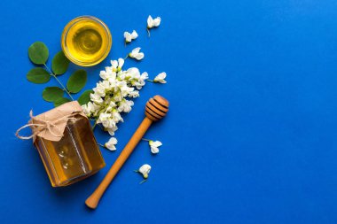 Akasya çiçekli ve yapraklı bal kavanozu. Taze bal üst görünüm düz yatıyordu.