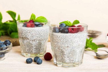 Sağlıklı kahvaltı ya da sabah chia tohumlu vanilyalı puding ahududu ve böğürtlen, vejetaryen gıda, diyet ve sağlık konsepti. Ahududu ve yabanmersinli Chia pudingi..