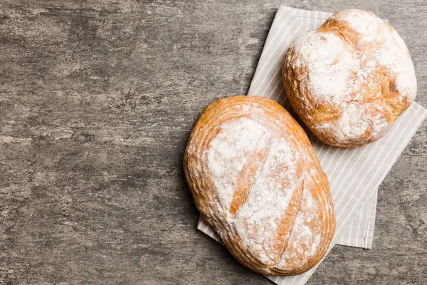Kırsal masa manzaralı peçeteli taze pişmiş ekmek çeşitleri. Sağlıklı mayasız ekmek. Fransız ekmeği.