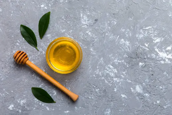 Bal kavanozu, beyaz arka plan manzaralı ve fotokopi alanı olan ahşap bal kaplama. Lezzetli bal şişesi.