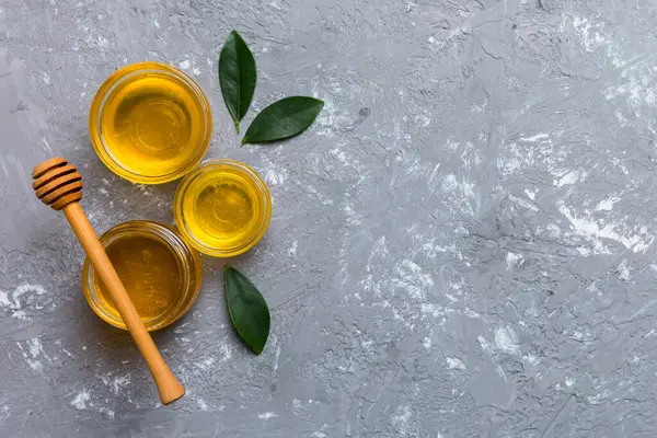 Bal kavanozu, beyaz arka plan manzaralı ve fotokopi alanı olan ahşap bal kaplama. Lezzetli bal şişesi.