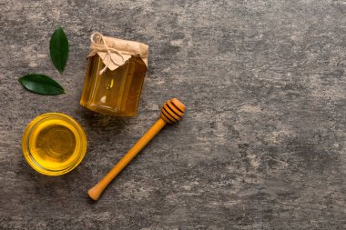 Bal kavanozu, beyaz arka plan manzaralı ve fotokopi alanı olan ahşap bal kaplama. Lezzetli bal şişesi.