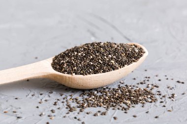 Ahşap kaşık ve chia tohumları renkli arka planda, üst manzara. Sağlıklı Salvia Hispanica Sağlıklı süper yiyecekler.