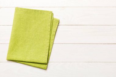 top view with green kitchen napkin isolated on table background. Folded cloth for mockup with copy space, Flat lay. Minimal style.