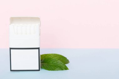 Bir paket mentollü sigara ve renkli masada taze nane şekeri, mentollü sigaralar düz yerde yatıyordu..