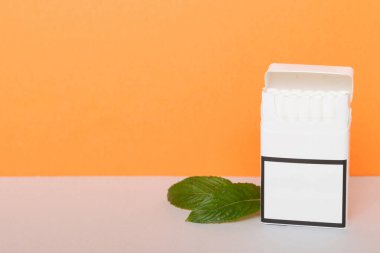 Bir paket mentollü sigara ve renkli masada taze nane şekeri, mentollü sigaralar düz yerde yatıyordu..