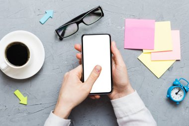 Mesajınız veya bilgi içeriğiniz için boş bir kopya ekranı olan akıllı telefonları tutan kadın ellerinin üst görünümü. üst görünümde telefon beyaz ekranı kullanan kadın eli.
