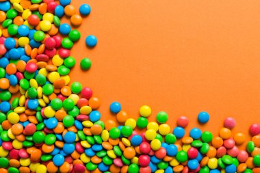 Renkli arka planda karışık renkli şeker koleksiyonu. Düz yerde, üst tarafta. Renkli çikolata kaplı şeker çerçevesi.