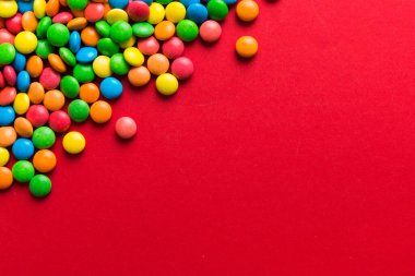 Renkli arka planda karışık renkli şeker koleksiyonu. Düz yerde, üst tarafta. Renkli çikolata kaplı şeker çerçevesi.
