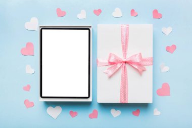 Gift box of open tablet for the holidays with a bow top view.