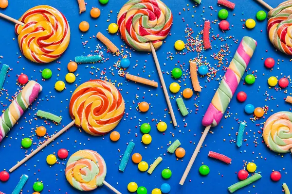 Lezzetli İştah açıcı Parti Aksesuarları Mutlu Yıllar Tatlı. Renkli arkaplanda farklı tipte şekerler, kopyalama alanı. Renkli doğum günü partisi geçmişi.