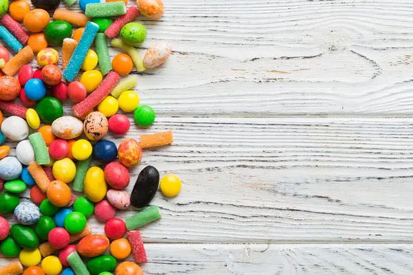 Renkli arka planda karışık renkli şeker koleksiyonu. Düz yerde, üst tarafta. Renkli çikolata kaplı şeker çerçevesi.