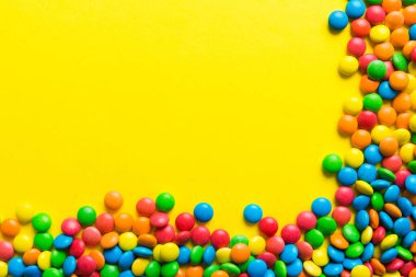 Renkli arka planda karışık renkli şeker koleksiyonu. Düz yerde, üst tarafta. Renkli çikolata kaplı şeker çerçevesi.