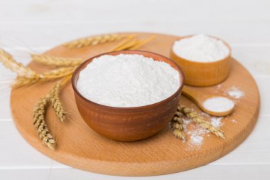 Tahta kasede buğday unu ve renkli arka planda buğday dikenleri. dünya buğday krizi.