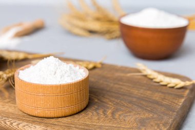 Tahta kasede buğday unu ve renkli arka planda buğday dikenleri. dünya buğday krizi.