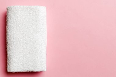 Renkli arkaplanda kopyalama alanı olan beyaz havluların üst görünümü.