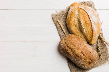 Kırsal masa manzaralı peçeteli taze pişmiş ekmek çeşitleri. Sağlıklı mayasız ekmek. Fransız ekmeği.