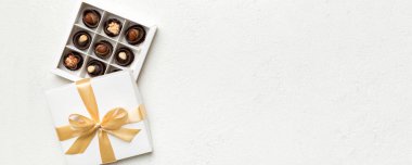 Çikolata ve altın bantlı beyaz kutu. Kopyalama alanı olan üst görünüm.