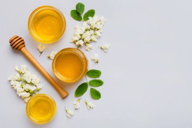 Akasya çiçekli ve yapraklı bal kavanozu. Taze bal üst görünüm düz yatıyordu.