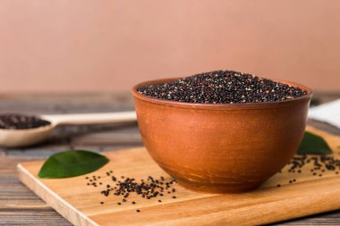 Kase içinde kinoa tohumu ve renkli arka planda kaşık. Küçük kasede sağlıklı kinwa. Sağlıklı süper yiyecekler.