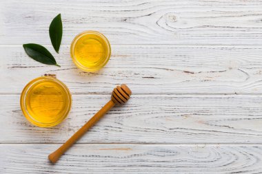 Bal kavanozu, beyaz arka plan manzaralı ve fotokopi alanı olan ahşap bal kaplama. Lezzetli bal şişesi.