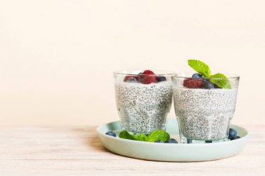 Sağlıklı kahvaltı ya da sabah chia tohumlu vanilyalı puding ahududu ve böğürtlen, vejetaryen gıda, diyet ve sağlık konsepti. Ahududu ve yabanmersinli Chia pudingi..