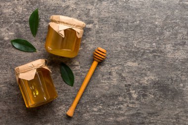 Bal kavanozu, beyaz arka plan manzaralı ve fotokopi alanı olan ahşap bal kaplama. Lezzetli bal şişesi.