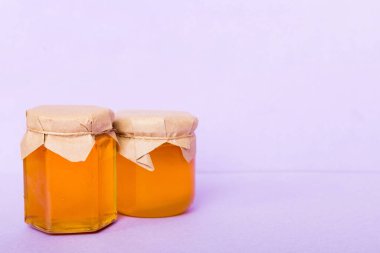 Renkli arka planda bal dolu cam kavanoz. Bal Şişesi Model.