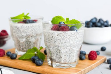 Sağlıklı kahvaltı ya da sabah chia tohumlu vanilyalı puding ahududu ve böğürtlen, vejetaryen gıda, diyet ve sağlık konsepti. Ahududu ve yabanmersinli Chia pudingi..