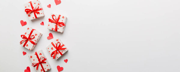 Valentine day composition: red gift box with bow and heart. Christmas present. View from above. Space for text. Holday greeting card.