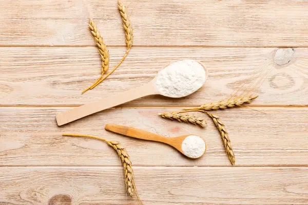 Tahta kasede buğday unu ve renkli arka planda buğday dikenleri. dünya buğday krizi.