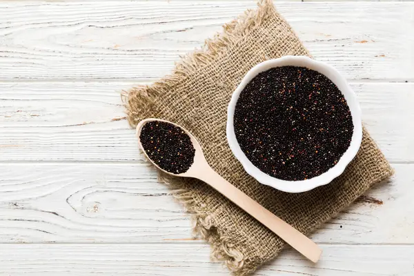 Kase içinde kinoa tohumu ve renkli arka planda kaşık. Küçük kasede sağlıklı kinwa. Sağlıklı süper yiyecekler.