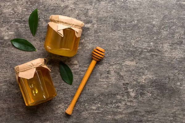 Bal kavanozu, beyaz arka plan manzaralı ve fotokopi alanı olan ahşap bal kaplama. Lezzetli bal şişesi.