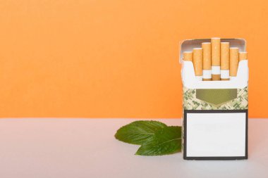 Bir paket mentollü sigara ve renkli masada taze nane şekeri, mentollü sigaralar düz yerde yatıyordu..