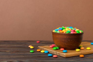 Renkli arka planda bir kasede çok renkli şekerler. Doğum günü ve tatil konsepti. Kopyalama alanı olan üst görünüm.