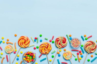 Lezzetli İştah açıcı Parti Aksesuarları Mutlu Yıllar Tatlı. Renkli arkaplanda farklı tipte şekerler, kopyalama alanı. Renkli doğum günü partisi geçmişi.