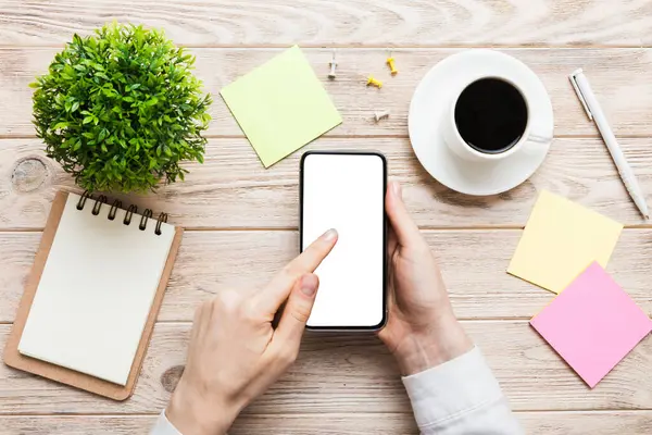 Mesajınız veya bilgi içeriğiniz için boş bir kopya ekranı olan akıllı telefonları tutan kadın ellerinin üst görünümü. üst görünümde telefon beyaz ekranı kullanan kadın eli.