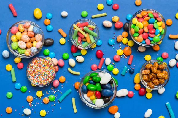 farklı renkte yuvarlak şekerler ve kavanozlar. Fotokopi alanı olan büyük çeşitlilikteki şeker ve şekerlerin üst görünümü.