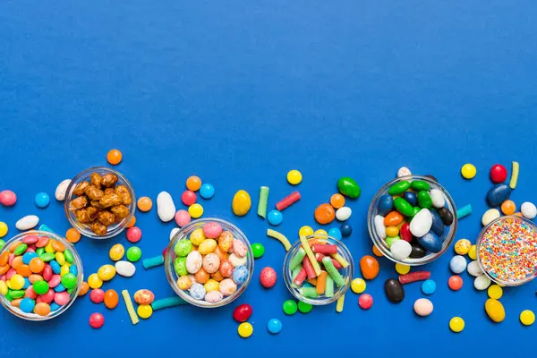 farklı renkte yuvarlak şekerler ve kavanozlar. Fotokopi alanı olan büyük çeşitlilikteki şeker ve şekerlerin üst görünümü.