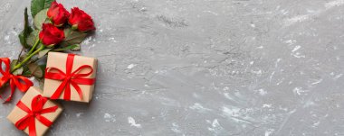 Gül çiçeği, kırmızı kalp ve hediye kutularıyla Sevgililer Günü kompozisyonu. Anneler günü ve doğum günü tebriği, kopyalama alanı, üst görünüm.