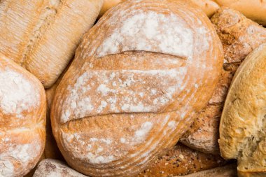 Ev yapımı doğal ekmek. Arka plan olarak farklı taze ekmek türleri, kopya alanı ile üst görünüm.