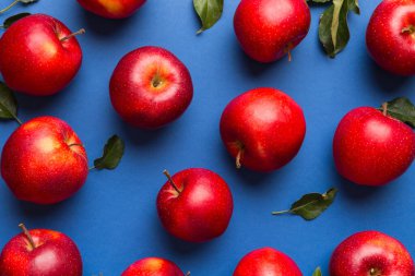 Renkli arka planda bir sürü kırmızı elma, üst manzara. Görüş üzerinde taze elma ile sonbahar deseni.