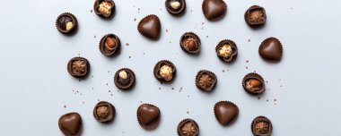 Renkli masa üzerinde farklı çikolata çeşitleri var. Üst Görünüm ve Düz Yatay.